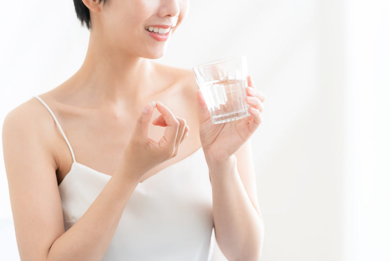 薬を飲む女性
